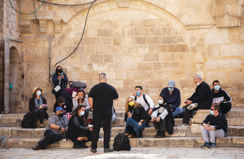 A rare sight these days – A group of tourists listen to their tour guide outside the Church of the Holy Sepulchre last year. (photo credit: HADAS PARUSH/FLASH90)