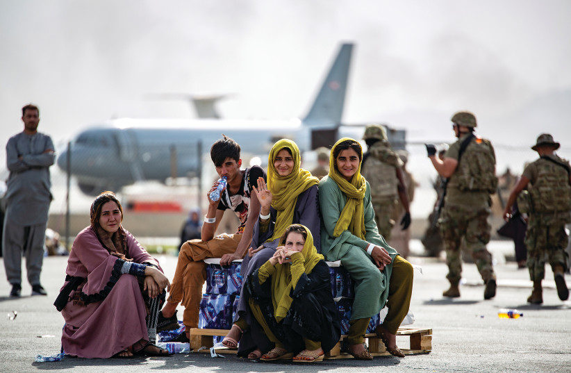 Evacuee children wait for a flight at Kabul’s airport in August amid the backdrop of the perception that the US’s Afghanistan withdrawal is having an impact across the Middle East. (photo credit: 1ST LT. MARK ANDRIES/US MARINE CORPS VIA REUTERS)