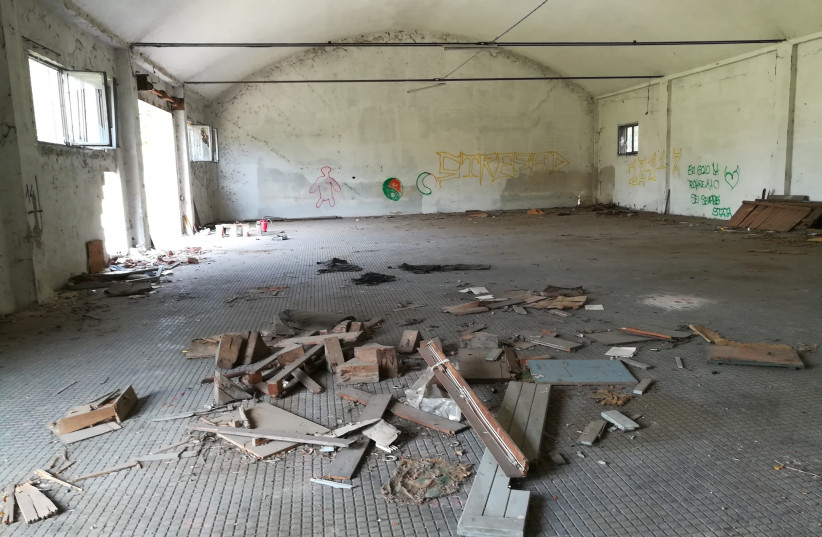  A view inside one of the abandoned warehouses at the site. (credit: GIOVANNI VIGNA/JTA)