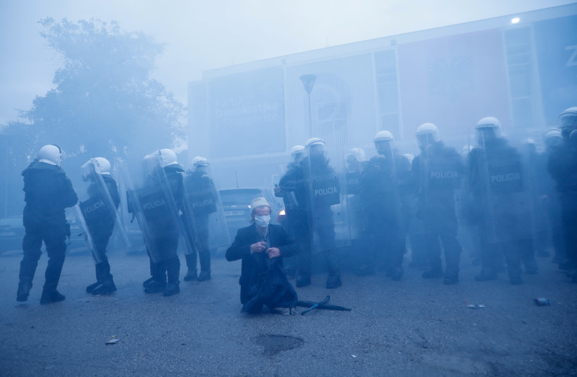  Police officers stand guard as protesters attack the headquarters of the Democratic Party in Tirana, Albania, January 8, 2022. (photo credit: REUTERS/FLORION GOGA)