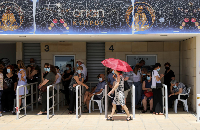  People wait outside a vaccination centre, amid the coronavirus disease (COVID-19) pandemic in Limassol, Cyprus May 4, 2021 (credit: YIANNIS KOURTOGLOU/REUTERS)
