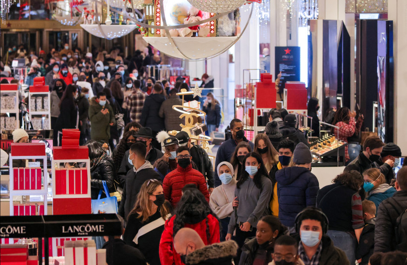  People in face masks shop in Macy's Herald Square on the last Saturday before Christmas as the Omicron coronavirus variant continues to spread, in Manhattan, New York City, U.S., December 18, 2021.  (photo credit: REUTERS/ANDREW KELLY)