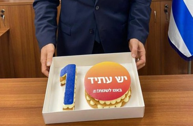  Foreign Minister Yair Lapid is seen holding a cake celebrating the 10 years of existence for his Yesh Atid Party. (photo credit: Roei Konkol)