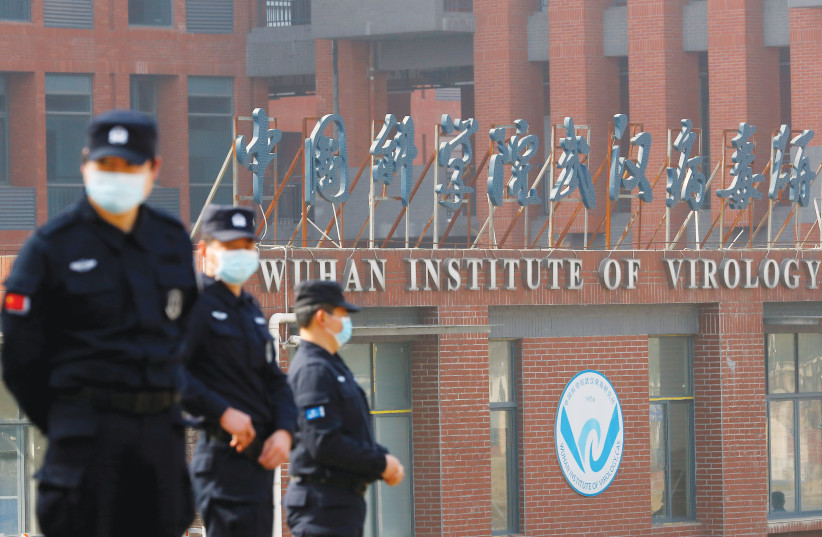  CHINESE SECURITY PERSONNEL keep watch outside the Wuhan Institute of Virology during a visit last year by a  World Health Organization team tasked with investigating the origins of COVID-19. (credit: THOMAS PETER/REUTERS)