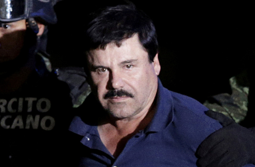 Recaptured drug lord Joaquin ''El Chapo'' Guzman is escorted by soldiers at the hangar belonging to the office of the Attorney General in Mexico City, Mexico, January 8, 2016. (credit: REUTERS/HENRY ROMERO/FILE PHOTO)