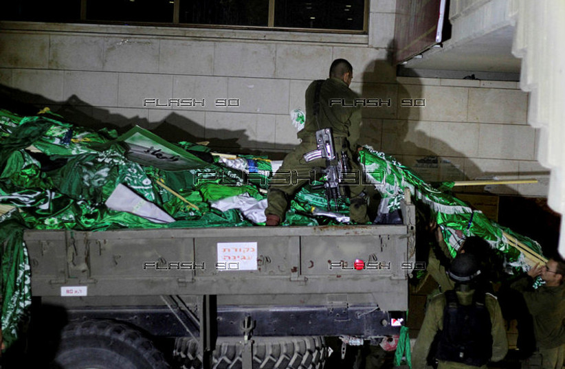  Israeli soldiers seen loading Hamas flags during a patrol at Birzeit University, on the outskirts of the city of Ramallah in the West Bank during an operation on June 19, 2014. (credit: ISSAM RIMAWI / FLASH 90)