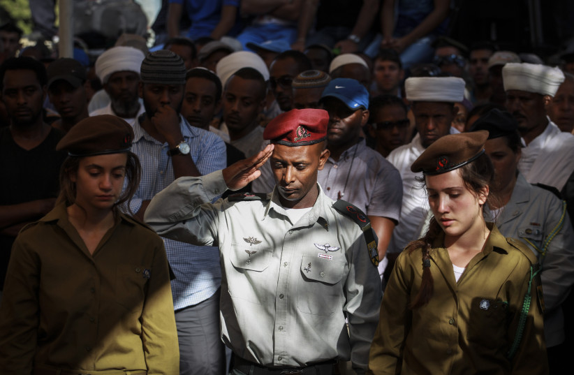  An Ethiopian soldier salutes the fresh grave of Golani soldier, Moshe Malko, at the Har Herzl Military Cemetery in Jerusalem, on July 21, 2014.  (credit: HADAS PARUSH/FLASH90)