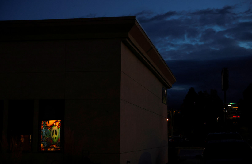  A piece of artwork is seen through the window of a gallery as the sun rises in Boise, Idaho, U.S., October 26, 2021.  (credit: REUTERS/SHANNON STAPLETON)