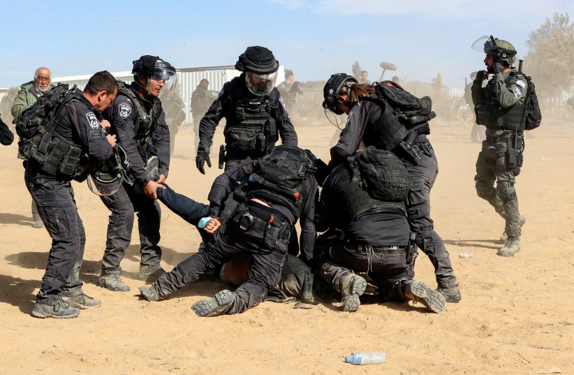  Israeli security forces detain a Bedouin man during a protest against forestation at the Negev desert village of Sawe al-Atrash, southern Israel January 12, 2022. (photo credit: REUTERS/AMMAR AWAD)