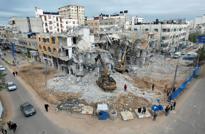 Bulldozers remove debris of Al-Jawharah Tower that was hit by Israeli air strikes during Israel-Palestine fighting last May, in Gaza City, December 21, 2021. Picture taken December 21, 2021. (photo credit: REUTERS/MOHAMMED SALEM)