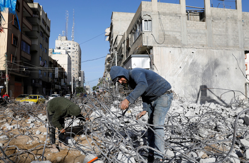 Workers sort out the rubble from Al-Jawharah Tower building that was hit by Israeli air strikes during the Israeli-Palestinian conflict in May last year, in Gaza City, January 10, 2022. (credit: REUTERS/SUHAIB SALEM)