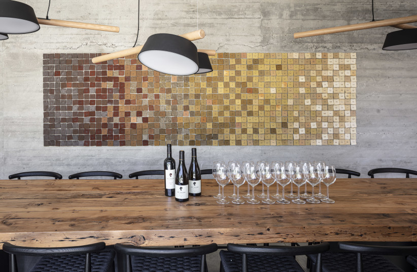 THE TASTING room with wooden table and distinctive wall display, which both tell a story. (credit: Bat Shlomo Vineyards)