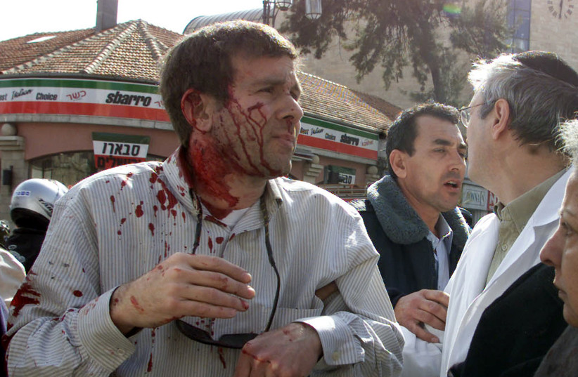  MARK SOKOLOW is taken to an ambulance after being injured in a suicide bombing in Jerusalem’s city center, January 27, 2002.  (photo credit: NIR ELIAS/REUTERS)