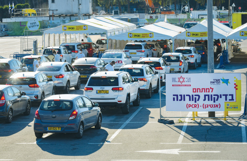 Cars line up at a drive-through COVID-19 testing center in Tel Aviv earlier this month. (photo credit: AVSHALOM SASSONI/FLASH90)