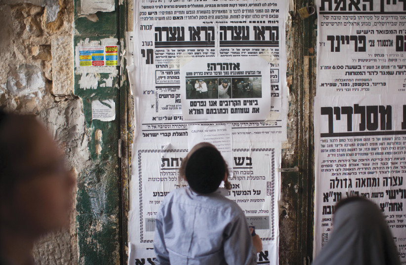  A HAREDI child reads a billboard in Mea She’arim. (credit: YONATAN SINDEL/FLASH90)