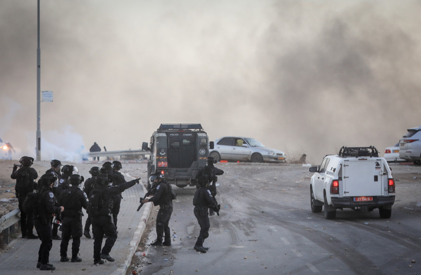 Israeli police officers clash with Bedouins during a protest against tree planting by the Jewish National Fund, outside the Bedouin village of al-Atrash in the Negev desert, southern Israel, January 13, 2022. (credit: JAMAL AWAD/FLASH90)
