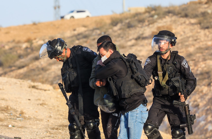  Israeli police officers clash with Bedouins during a protest against tree planting by the Jewish National Fund, outside the Bedouin village of al-Atrash in the Negev desert, southern Israel, January 13, 2022. (photo credit: JAMAL AWAD/FLASH90)