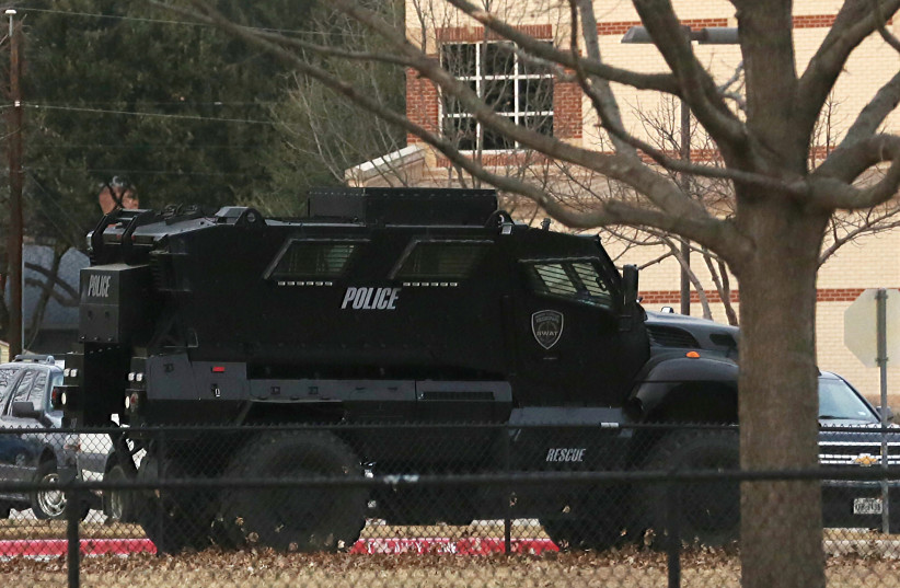 A law enforcement vehicle is parked at a school in the area where a man believed to have taken people hostage at a synagogue during services that were being streamed live, in Colleyville, Texas, US, January 15, 2022. (photo credit: REUTERS/Shelby Tauber)