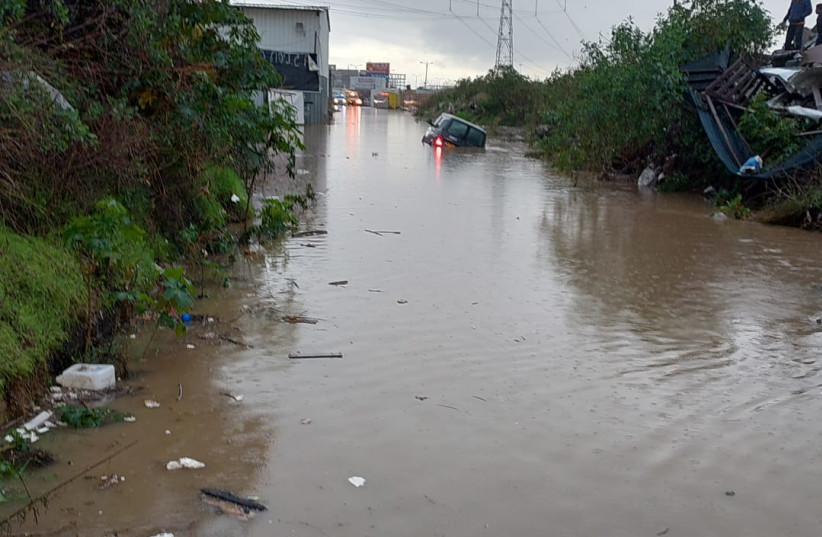  A car stands stuck in the middle of the road after streets flooded during heavy rains and storms throughout Israel, Kafr Qassem, 2022 (credit: FIRE AND RESCUE SERVICE)