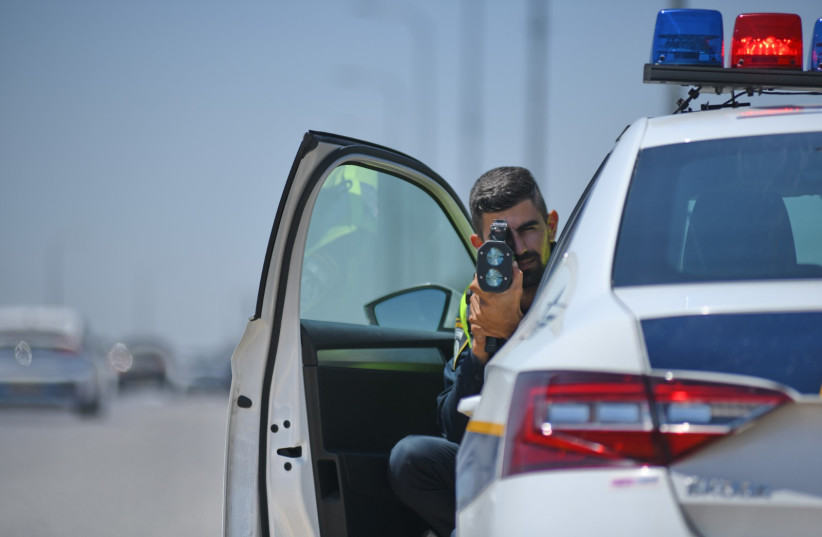  A police officer uses a radar speed gun to track drivers in violation of the speed limit, 2022 (photo credit: POLICE SPOKESPERSON'S UNIT)
