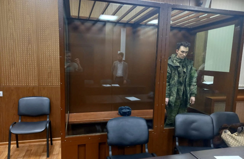 Artyom Zayets, detained on suspicion of the illegal circulation of means of payment as a member of the REvil ransomware crime group, stands inside a defendants' cage during a court hearing in Moscow, Russia, January 15, 2022. (photo credit: PRESS SERVICE OF TVERSKOY DISTRICT COURT OF MOSCOW/HANDOUT VIA REUTERS)