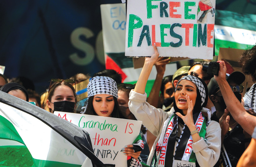 PRO-PALESTINIAN supporters demonstrate across the street from the Israeli Consulate in New York City. It is unreasonable to expect Jewish students to check their support for Israel at the door. (credit: CARLO ALLEGRI/REUTERS)