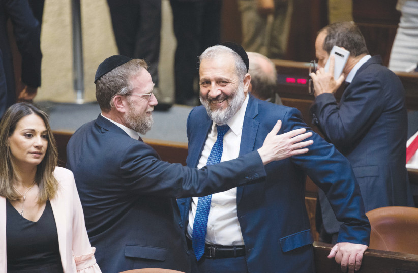  THE WRITER shares a light moment in the Knesset plenum with Shas leader MK Arye Deri. (photo credit: YONATAN SINDEL/FLASH90)