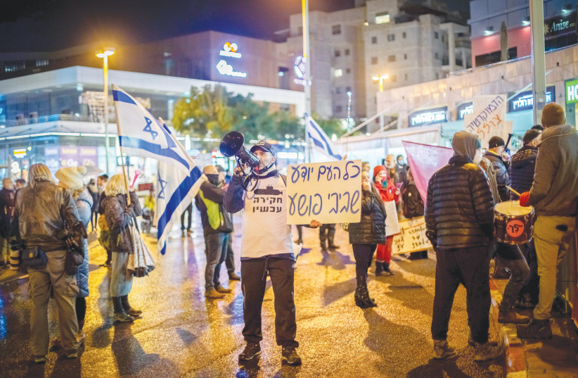  DEMONSTRATORS PROTEST against a plea deal with former prime minister Benjamin Netanyahu, near the home of Attorney-General Avichai Mandelblit, in Petah Tikva, on January 15. The poster, which rhymes in Hebrew, reads: ‘The whole country knows, Bibi is a criminal.’ (photo credit: CHEN LEOPOLD/FLASH90)