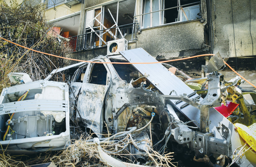  DAMAGE IS caused to a residential building, a vehicle and other property after rockets from the Gaza Strip hit Petah Tikva last May.  (credit: AVSHALOM SASSONI/FLASH90)