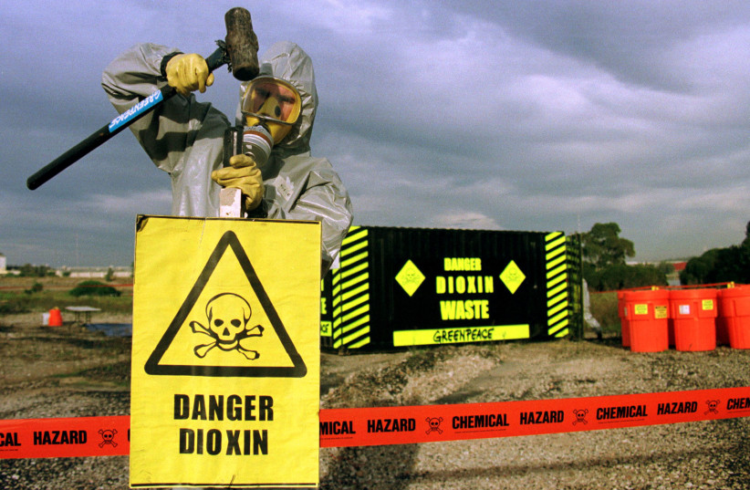  A Greenpeace activist hammers into the ground warning signs (credit: DAVID GRAY / REUTERS)