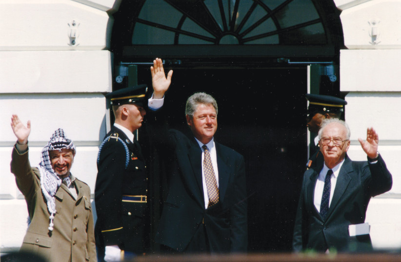  THEN-PLO chairman Yasser Arafat, then-US president Bill Clinton and then-prime minister Yitzhak Rabin wave after the signing of the Declaration of Principles at the White House on September 13, 1993. (credit: GARY HERSHORN/REUTERS)