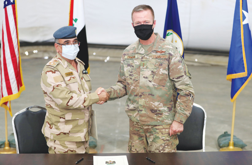  MAJOR GENERAL Kenneth P. Ekman shakes hands with Brigadier General Salah Abdullah at a ceremony handing over Taji military base, north of Baghdad, in August from US-led coalition troops to Iraqi security forces.  (photo credit: THAIER AL-SUDANI/REUTERS)