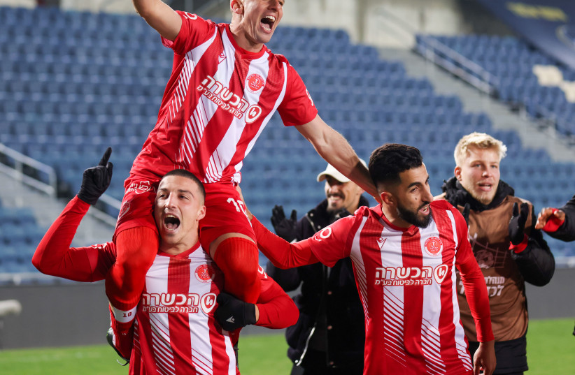  HAPOEL TEL AVIV players celebrates on the pitch after their 2-0 victory over host Beitar Jerusalem (inset) in Premier League action on Monday night at Teddy Stadium. (photo credit: DANNY MARON)