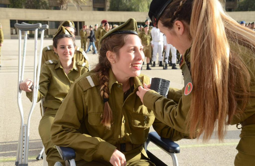  Ofir's commander at IDF Officers' School presents her with an officer's pin in the final ceremony, three weeks after the attack (photo credit: Ofir Family)
