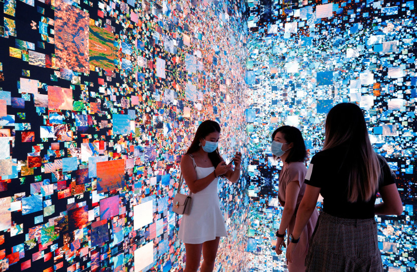  Visitors are pictured in front of an art installation titled 'Machine Hallucinations - Space: Metaverse' by media artist Refik Anadol (photo credit: TYRONE SIU/ REUTERS)
