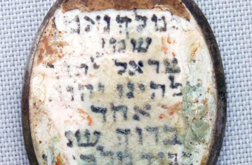  Pendentif portant shema yisrael trouvé au camp d'extermination de Sobibor en Pologne, le 27 janvier 2021. (Crédit : IAA)