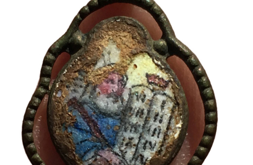  Pendant bearing an image of Moses carrying the tablets found at Sobibor extermination camp in Poland, January 27, 2021. (credit: IAA)