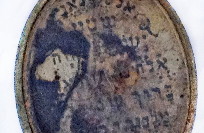 Représentation de Moïse et des tables de la Loi sur le pendentif découvert dans la zone où les femmes étaient déshabillées avant d'être conduites aux chambres à gaz. (crédit : YORAM HAIMI/IAA)