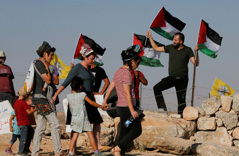  Palestinians protest as Jewish settlers march in West Bank (photo credit: REUTERS/MUSSA QAWASMA)