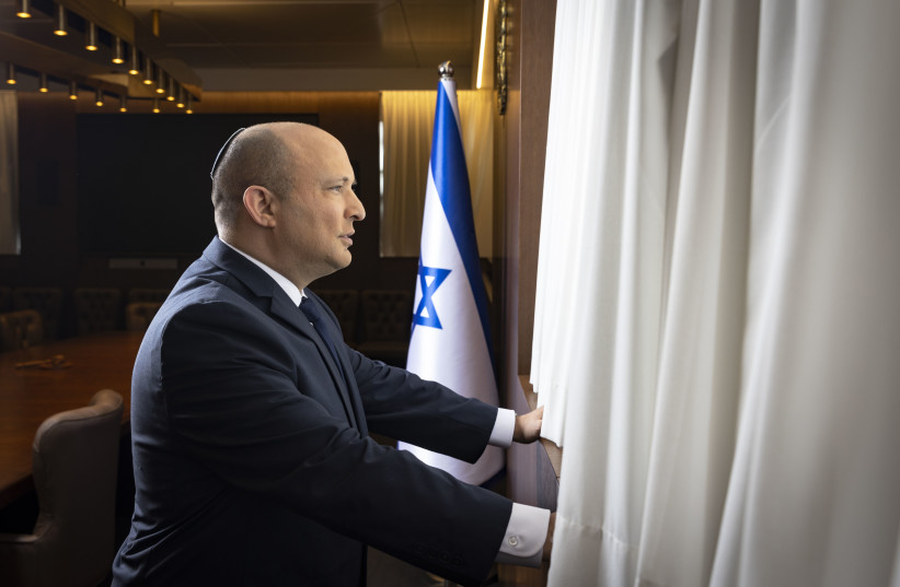  Prime Minister Naftali Bennett is seen looking out of his office window. (credit: OLIVIER FITOUSSI)