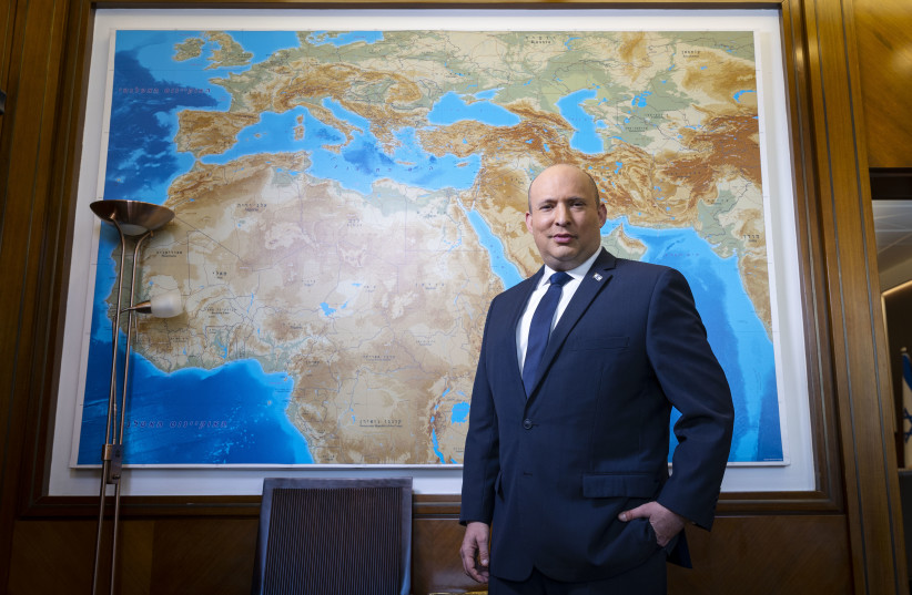  Prime Minister Naftali Bennett stands before a map of the region in his office. (photo credit: OLIVIER FITOUSSI)