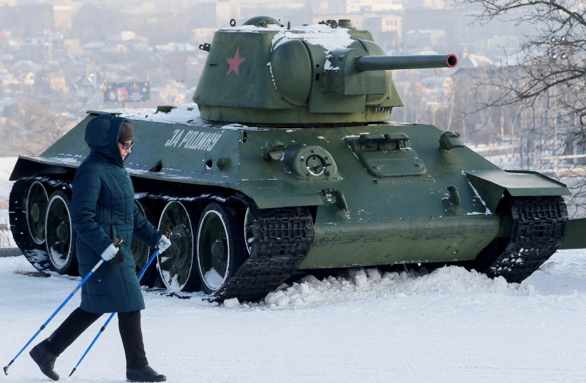  A woman passes by a T-34 tank and other Soviet-era military vehicles while practising nordic walking in a park in the rebel-held city of Donetsk, Ukraine January 27, 2022. (credit: REUTERS/ALEXANDER ERMOCHENKO)
