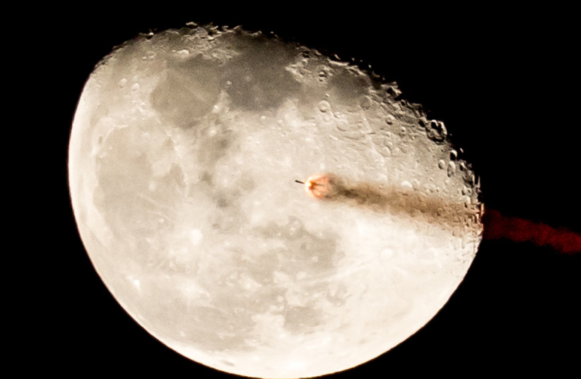  A falcon rocket is seen flying by the Moon in this artistic illustration. (credit: David Baker/Flickr)