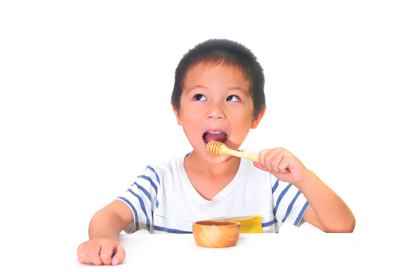 Child eating honey (Illustrative) (photo credit: PIXABAY)