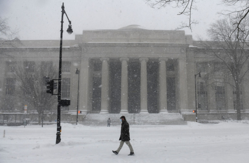   A pedestrian makes their way through snow outside the MIT School of Architecture and Planning during a powerful Nor'easter storm in Cambridge, Massachusetts, U.S., January 29, 2022. (photo credit: NICHOLAS PFOSI/REUTERS)