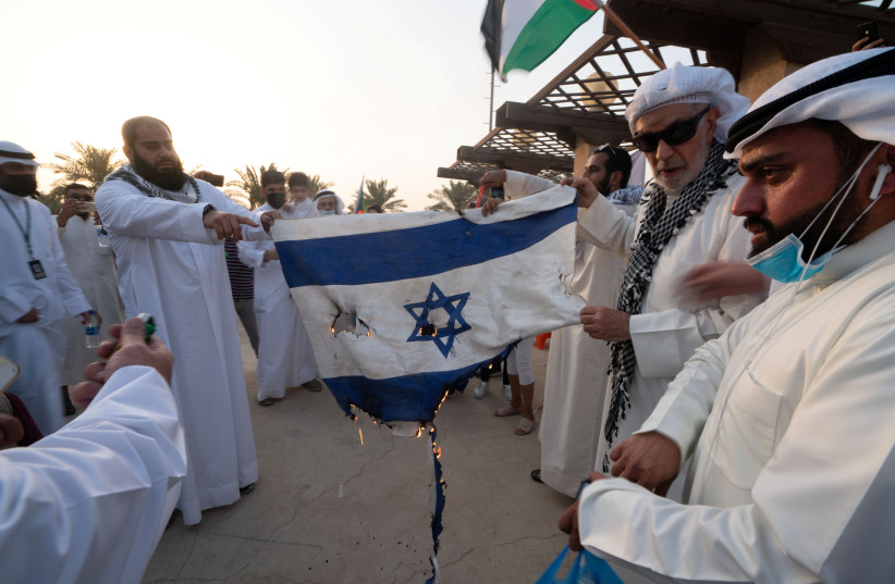  Demonstrators burn an Israeli flag during a protest to express solidarity with the Palestinian people amid a flare-up of Israeli-Palestinian violence, in Kuwait City, Kuwait May 19, 2021 (credit: REUTERS/STEPHANIE MCGEHEE)