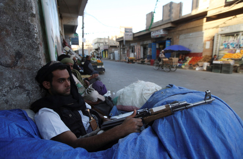   A Shi'ite Houthi fighter sits behind sandbags near a checkpoint in Sanaa December 17, 2014 (photo credit: REUTERS/MOHAMED AL-SAYAGHI)