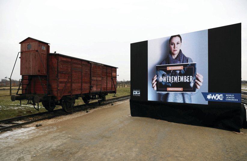  VIEW OF a train car and screen display at the site of Auschwitz-Birkenau during ceremonies marking the 77th anniversary of the liberation of the camp and International Holocaust Remembrance Day last week. (photo credit: Jakub Porzycki/Agencja Wyborcza/Reuters)