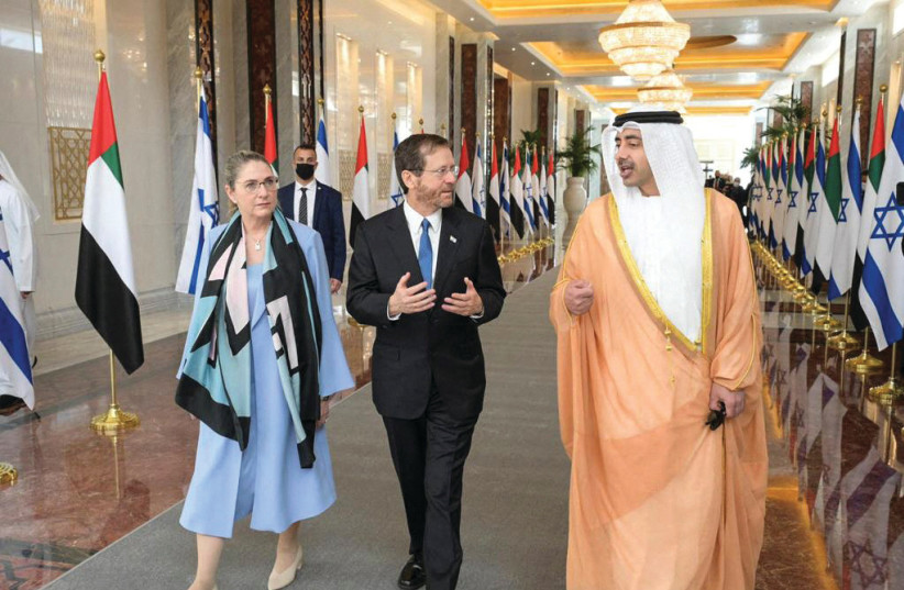  President Isaac Herzog, his wife Michal, and UAE Foreign Minister Sheikh Abdullah bin Zayed Al Nahyan walk through the airport after Herzog's arrival in Abu Dhabi.  (photo credit: AMOS BEN GERSHOM/GPO)