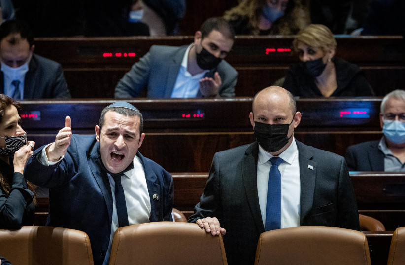  Israeli prime minister Naftali Bennett and MK Yomtob Chai Kalfon seen during a discussion on the Electricity Law connecting to Arab and Bedouin towns, during a plenum session in the assembly hall of the Israeli parliament in Jerusalem, January 5, 2022. (credit: YONATAN SINDEL/FLASH90)